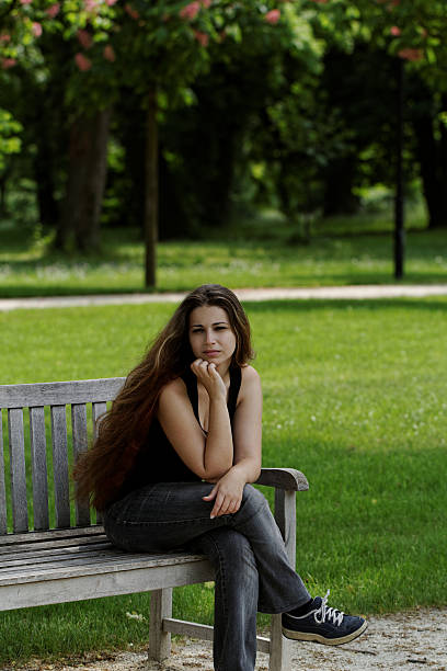 istock pretty young girl on a bench 187855276
