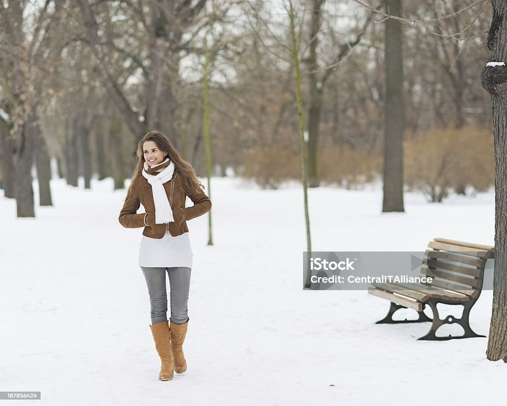 Happy young woman walking in winter park Adult Stock Photo