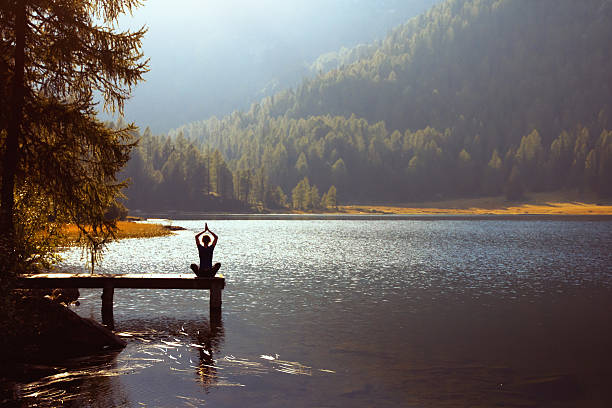 yoga on the lake - zen like nature breathing exercise sitting стоковые фото и изображения