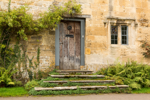 Ancient oak front door to cottage in Stanton in Cotswold or Cotswolds district of southern England in the autumn.