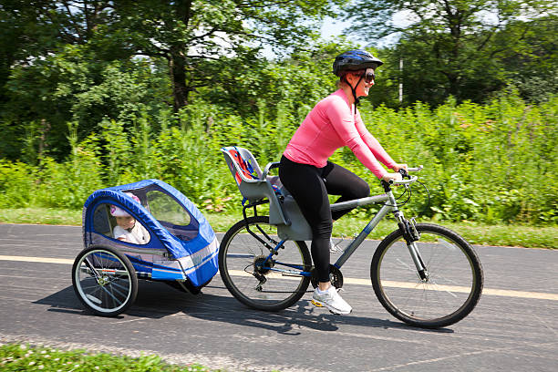 Woman on bike with trailer stock photo