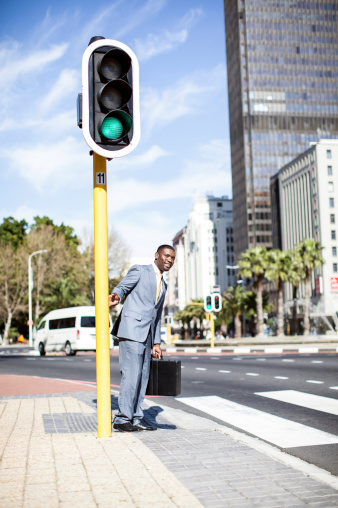 African businessman preparing to cross the road in Cape Town, South Africa