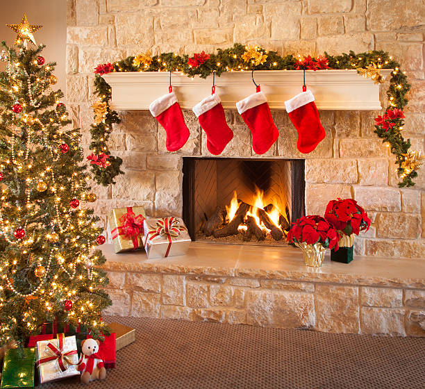 Christmas stockings, fire in fireplace, tree, and decorations Christmas tree, and stockings hanging from mantel by fireplace. Waiting for Santa. brightly lit winter season rock stock pictures, royalty-free photos & images