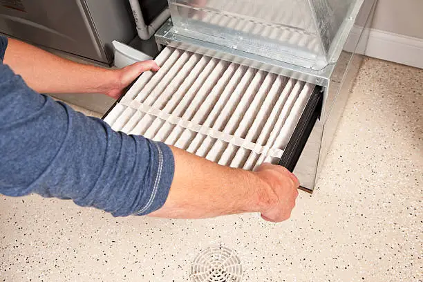 Photo of Hands Changing Furnace Air Filter