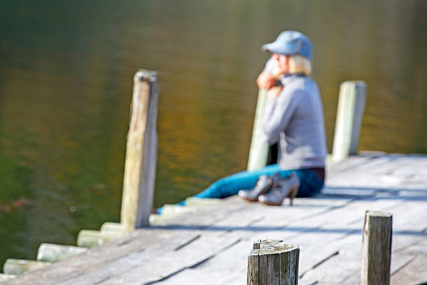 istock Woman sitting on dock with shoes 187866406