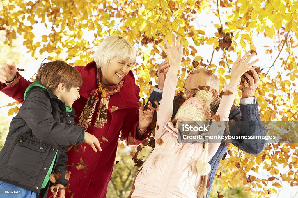 Grands-parents et petits-enfants avec les feuilles de l'automne dans le jardin - Photo de Automne libre de droits