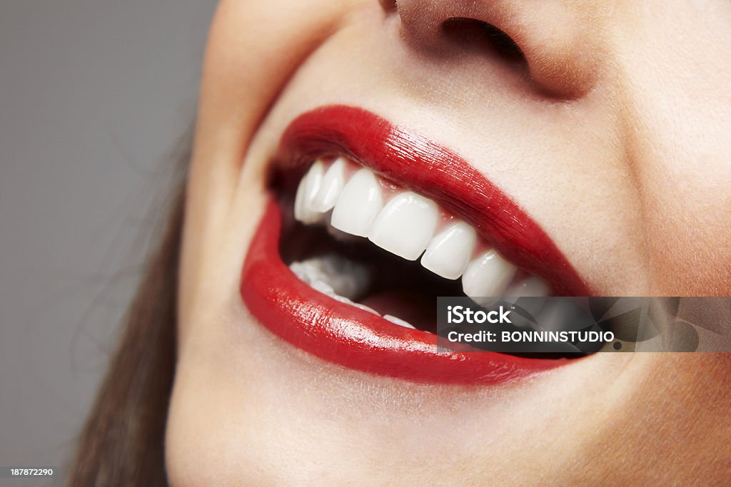 Smiling woman mouth with great teeth. Over white background Red lips in a young woman. Smiling Stock Photo