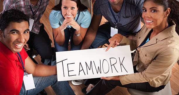 istock Business: Team works together.  Holds 'teamwork' sign. 187875053
