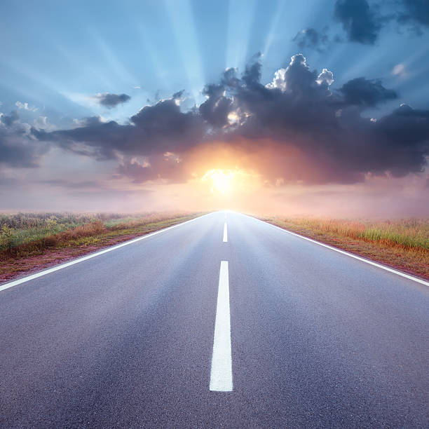 istock Driving on an empty road towards the rising sun 187875706