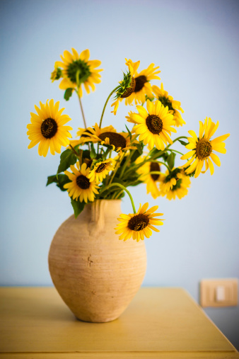some beautiful sunflowers in a hand made rustic clay pot