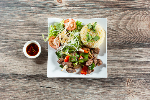 A top down view of a plate of shaken beef and fried rice.