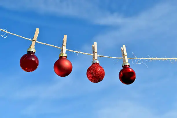 Small Christmas baubles hanging on a clothesline.