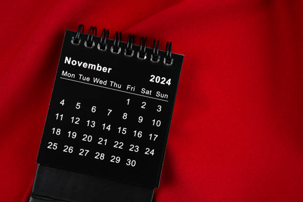 istock November 2024 Black spiral desktop calendar on textile. 1878843914