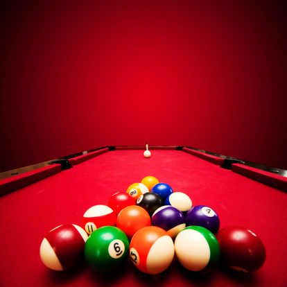 Billards pool game. Color balls in triangle, aiming at cue ball. Red cloth table