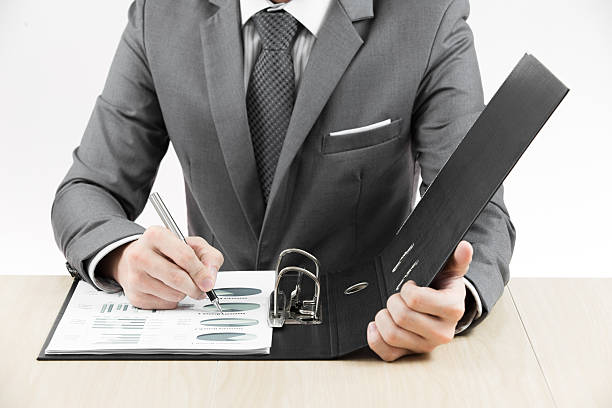 istock man hand with pen and business report 187886033