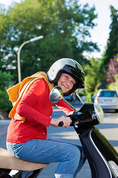 istock Vivacious elderly woman riding a scooter. 187886043