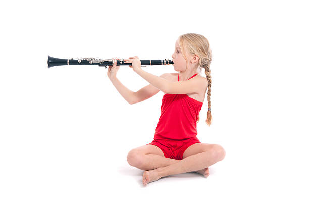 istock young sitting girl in red playing clarinet 187887627