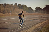 Teen rides a bicycle on the road