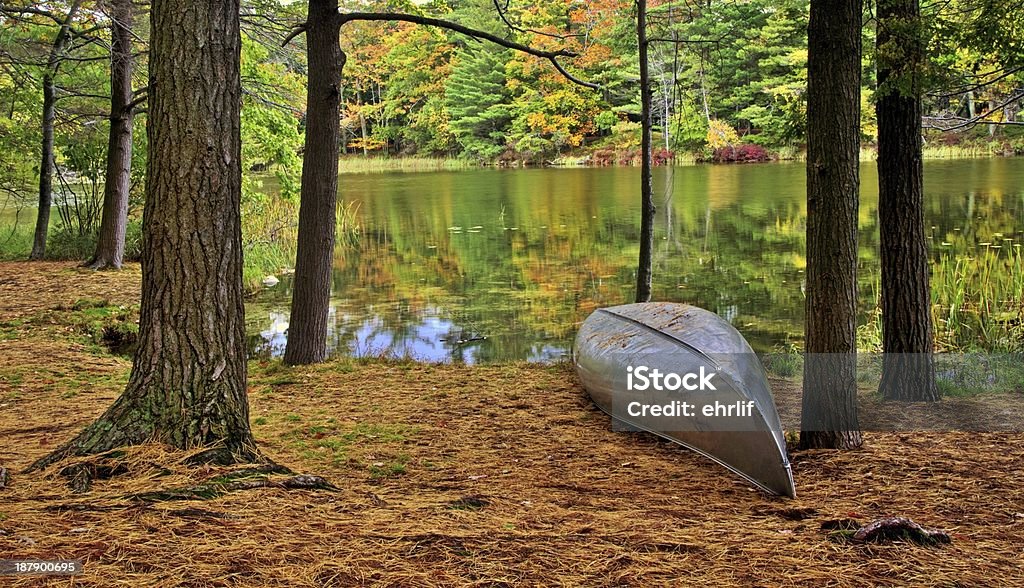 Canoe On The Shore Aluminum canoe on the shore of Lost Lake with the autumn forest as the backdrop. Ludington State Park. Ludington, Michigan. Ludington - Michigan Stock Photo
