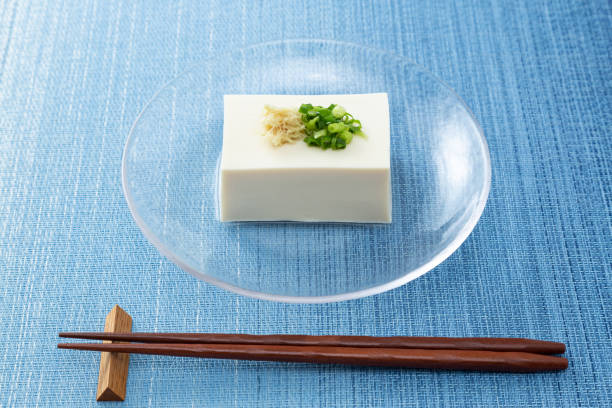 tofu auf blauem hintergrund. - chopsticks soybean japanese cuisine blue stock-fotos und bilder