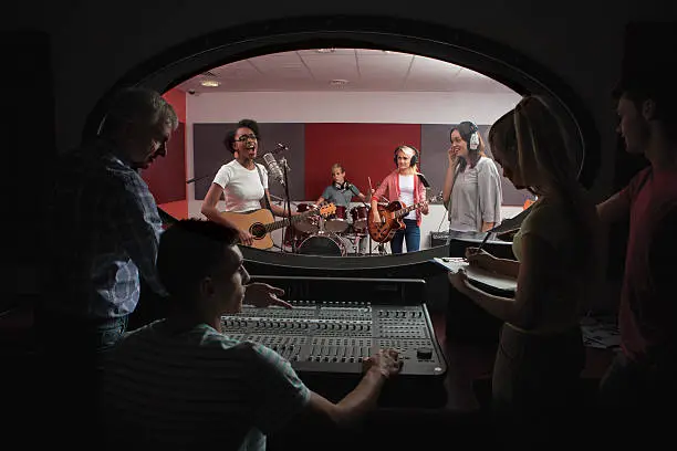 Mixed group of people recording in a studio with instruments