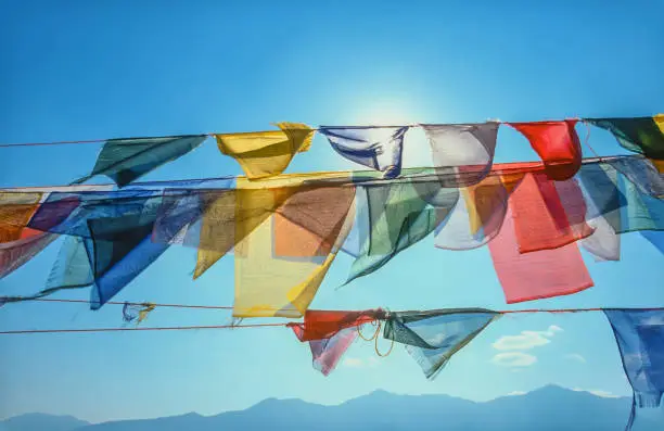 Photo of Colorful Buddhist prayer flags blowing in the wind