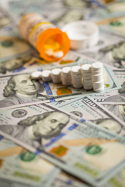 istock Medicine Pills Stacked on Newly Designed One Hundred Dollar Bill 187903732