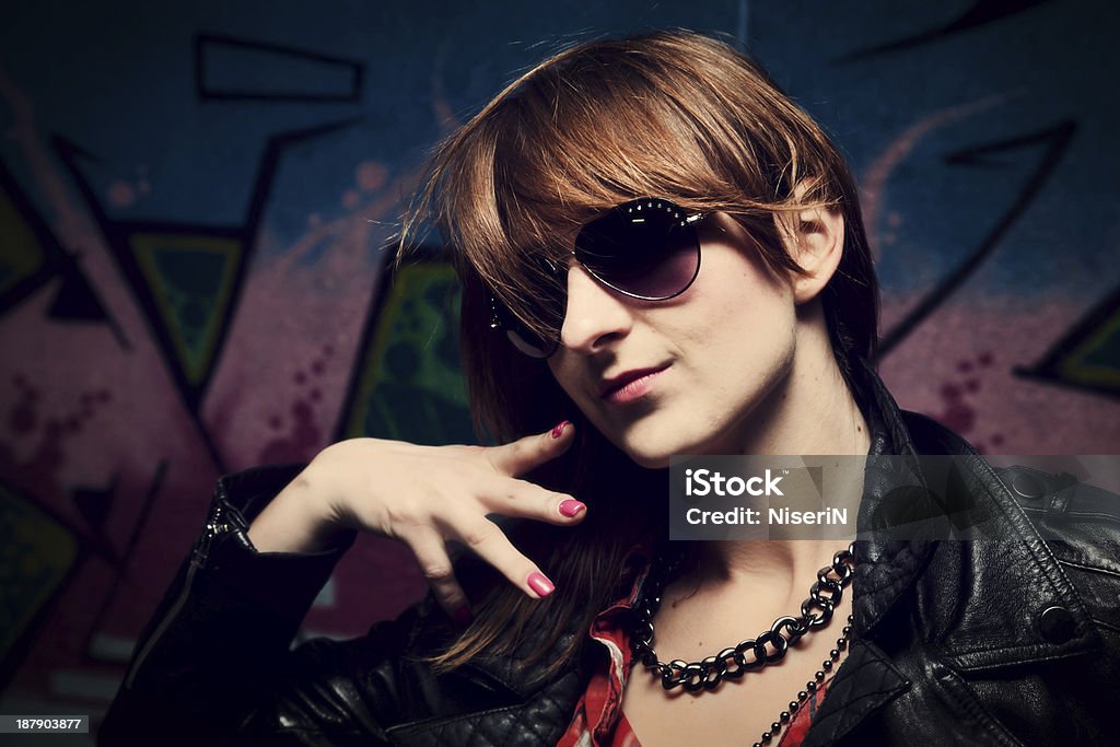 Fashionable girl and colorful graffiti wall Stylish fashionable girl posing against colorful graffiti wall. Fashion, trends, subculture Adult Stock Photo