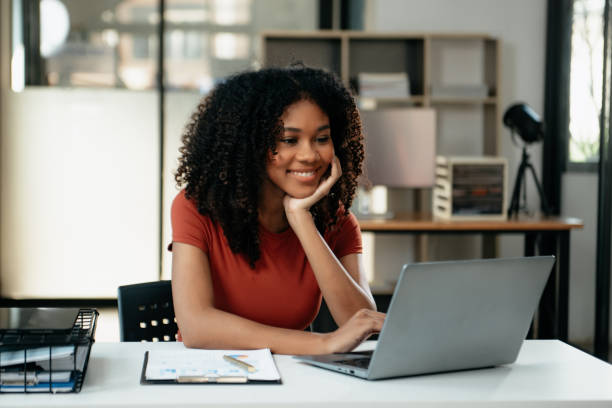 istock Young woman typing on tablet and laptop while sitting at the working in office 1879074094