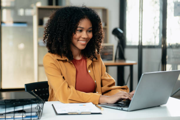 istock Young woman typing on tablet and laptop while sitting at the working in office 1879074100