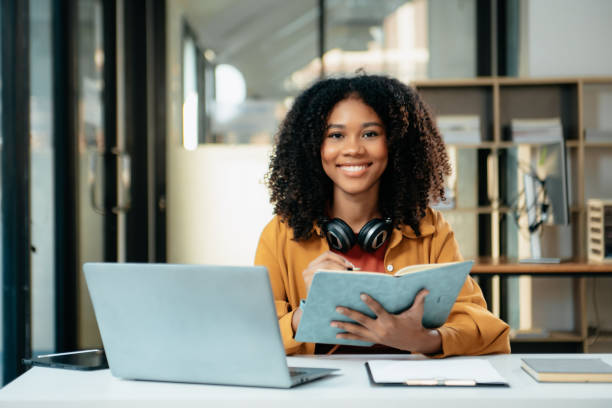 istock Young woman typing on tablet and laptop while sitting at the working in office 1879074247