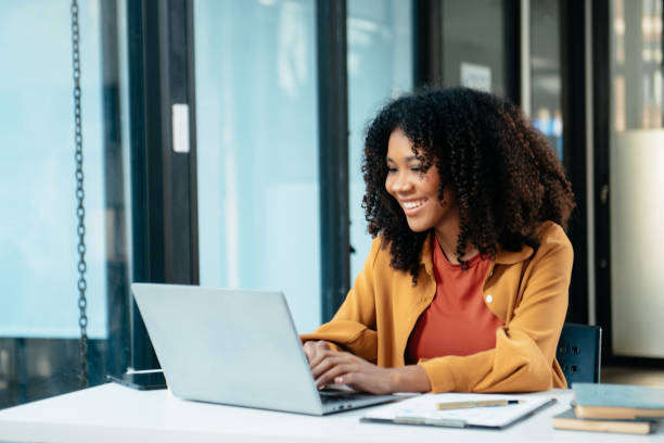 istock Young woman typing on tablet and laptop while sitting at the working in office 1879074617