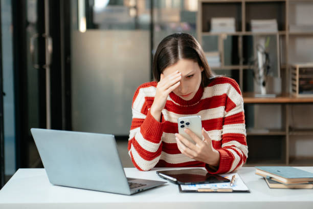 Business woman is stressed, bored, and overthinking from working on a tablet at office.