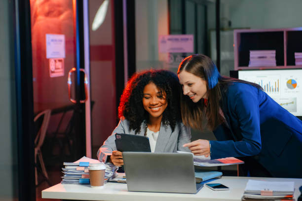 istock Two business workers talking on the smartphone and using laptop at the office. overtime 1879074678