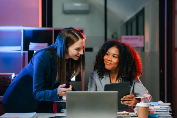 istock Two business workers talking on the smartphone and using laptop at the office. overtime 1879074680