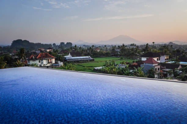 istock Blue swimming pool in hotel rooftop with beautiful mountain and rice paddy fields view in the morning. Swimming pool and relaxing area in the apartment. 1879077752