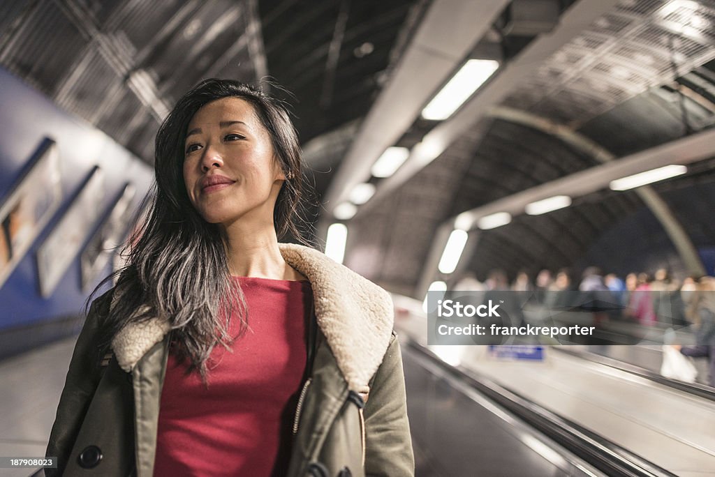 Donna cinese con le scale mobili - Foto stock royalty-free di Metropolitana di Londra