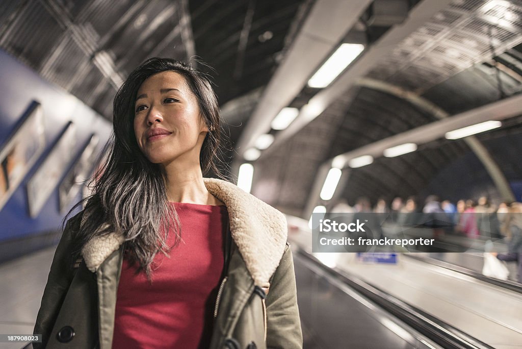 Mulher chinesa em escadas rolantes - Foto de stock de Metro de Londres royalty-free