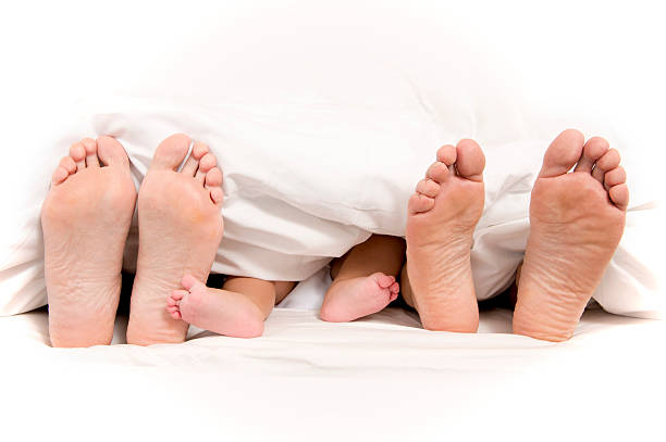 istock Mother Father and Baby Feet under Blanket 187908341