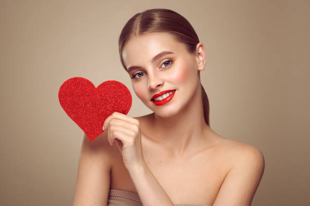 istock Beautiful woman holding an artificial red heart 1879100424