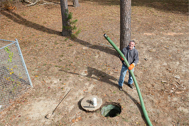 istock Septic Tank Worker Holds Sewage Hose 187910325