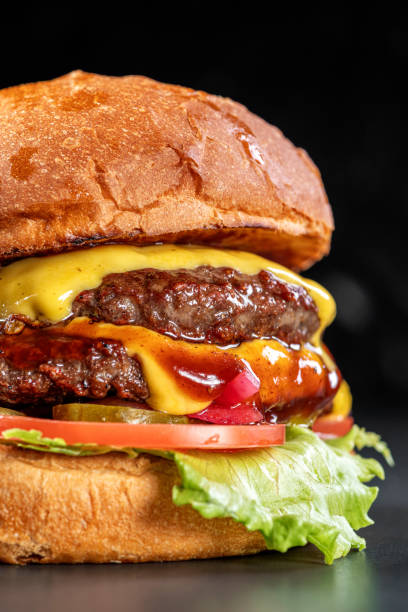 istock Delicious double cheeseburger close up on a black background. Delicious cheeseburger. sandwich fast food, amazing food 1879112724