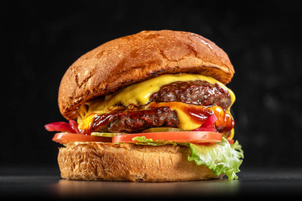 istock Delicious double cheeseburger close up on a black background. Delicious cheeseburger. sandwich fast food, amazing food 1879112733