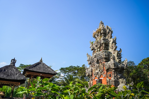 Bali, Indonesia - October 19, 2023: Balinese traditional temple building called pura with clear blue sky background during the day. Concept for Bali Tourism, Indonesia tropical island tourist destination.