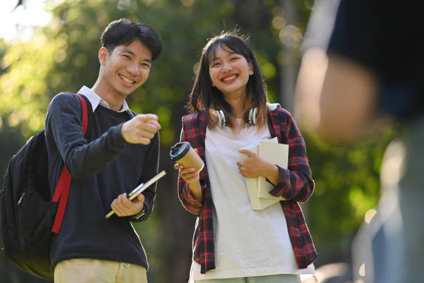istock Two Asian students pointing at a student and laughing and mocking each other, Bullying within the school 1879118946