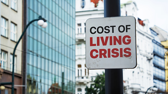 Cost of Living Crisis written on a sign in front of office buildings