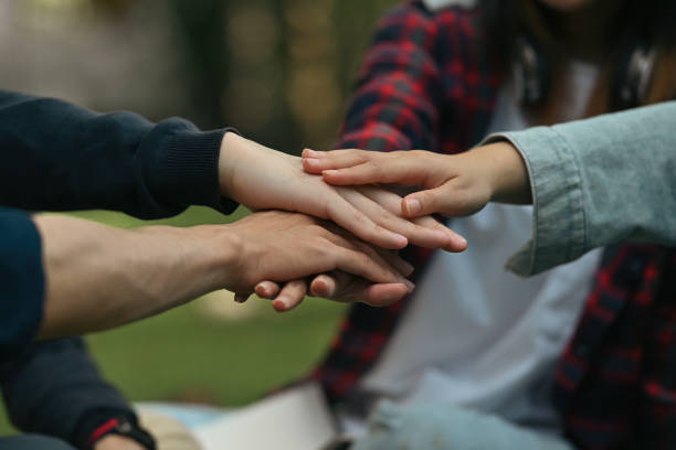 istock Close-up image of group of university students stacking hands together symbolizes unity and friendship supporting 1879125467