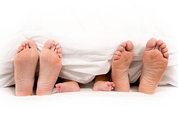 istock Mother Father and Baby Feet under Blanket 187912634
