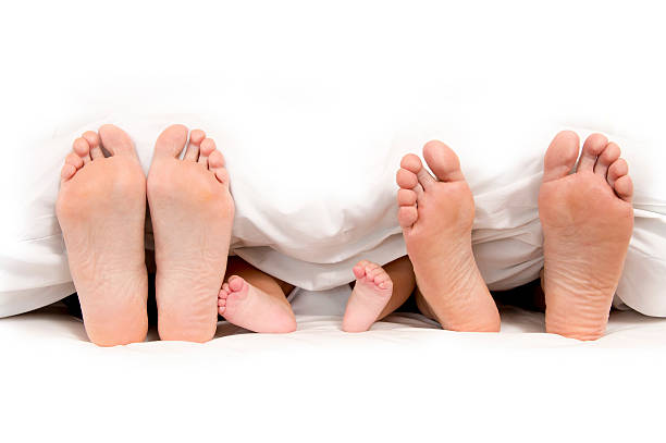Mother Father and Baby Feet under Blanket isolated on white background