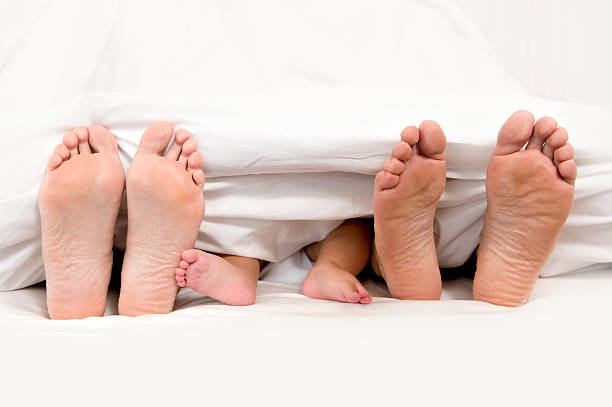 istock Mother Father and Baby Feet under Blanket 187914606